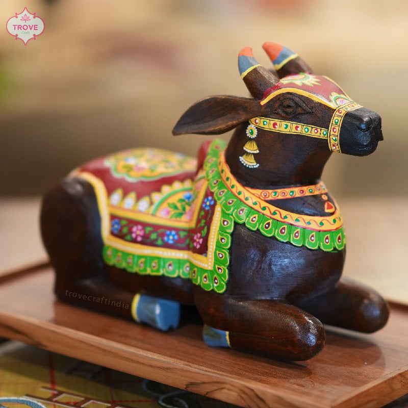 carved nandi with dark red painted rajasthani floral blanket