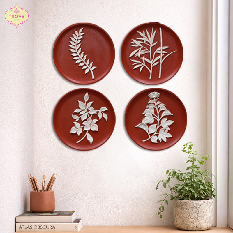 Round terracotta wall plates with white botanical relief designs